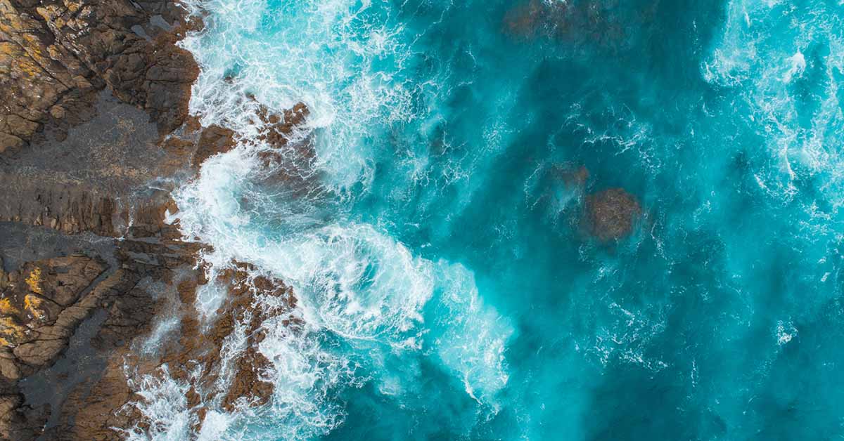 top view of waves crashing on rocks