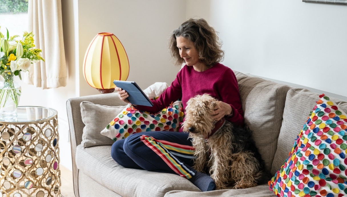 Female international investor on sofa looking at tablet